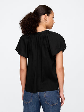 Top con mangas abullonadas y cuello dividido.