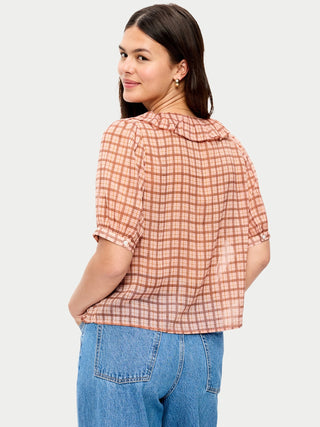 Blusa de gasa con cuello con volantes y lazo en el frente.