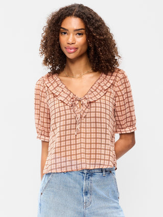 Blusa de gasa con cuello con volantes y lazo en el frente.